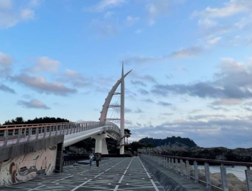 Jeju: Seogwipo City Walking Tours with Sunset - Crossing Saeyeongyo Bridge at sunset
